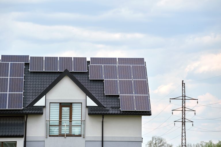 Private home roof covered with solar photovoltaic panels for generating of clean ecological electric energy in suburban rural town area